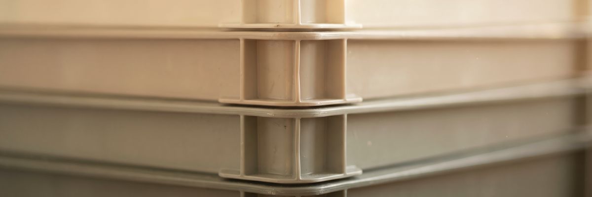 A stack of identical plastic storage crates seen from the side.